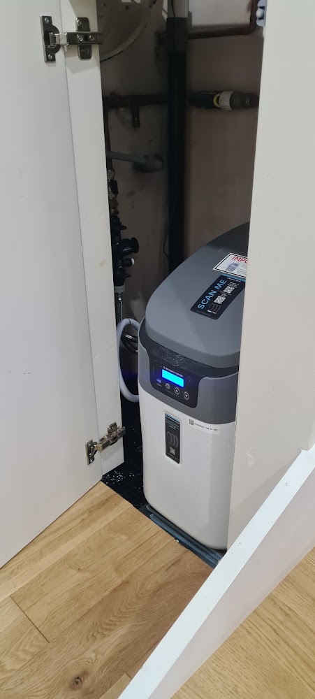 Water softener installed inside a kitchen cupboard